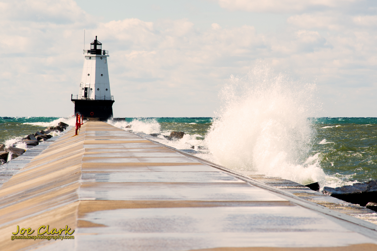 Ludington Light is swatted with small waves from both directions by Joe Clark www.glasslakesphotography.com